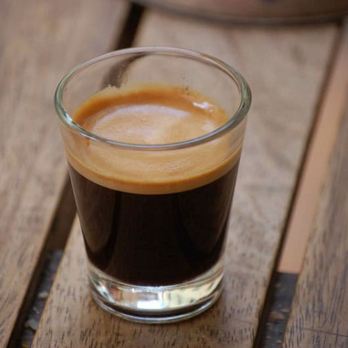 Ly cà phê espresso trên bàn gỗ – thực phẩm chứa caffeine cực kỳ nguy hiểm cho chó Chow Chow